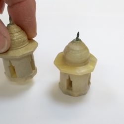 Fingers picking up miniature Taj Mahal turret