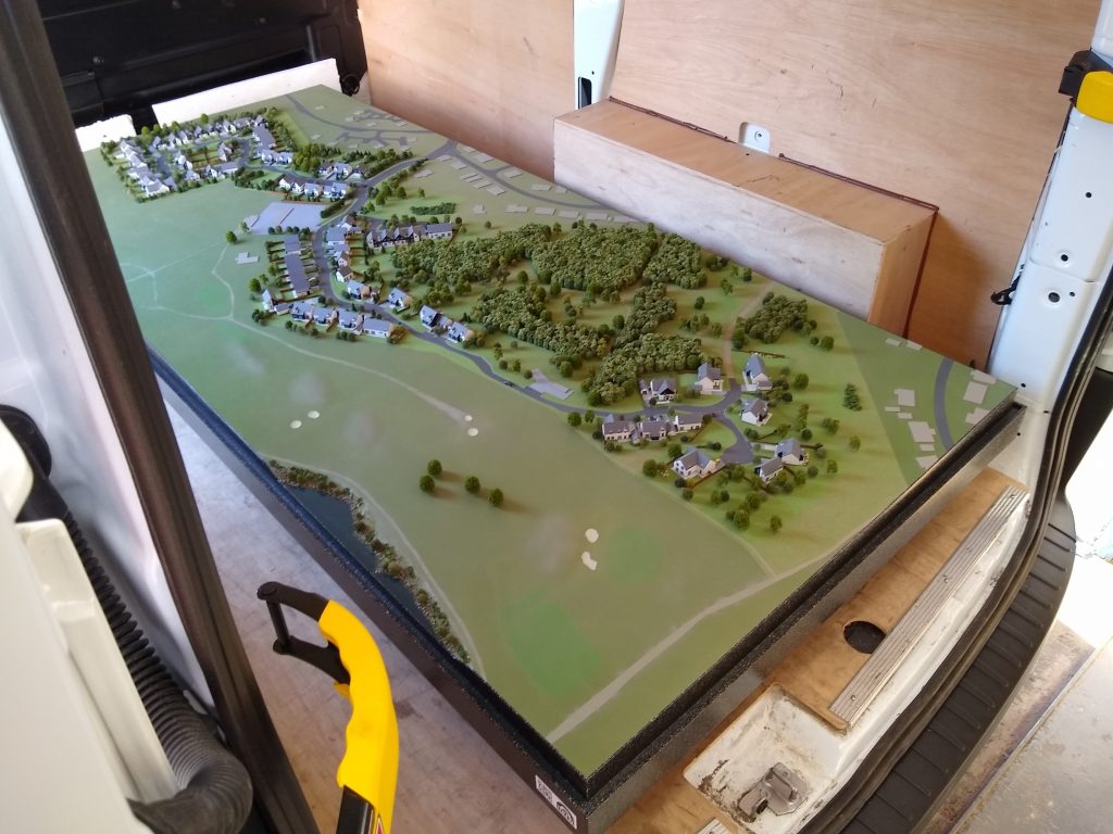 Scale model of a golf course in the back of a van